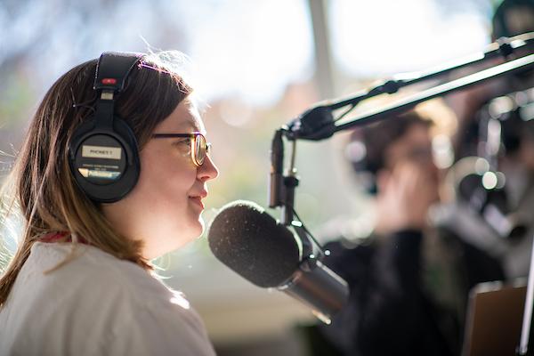 Student talks into microphone in podcast studio