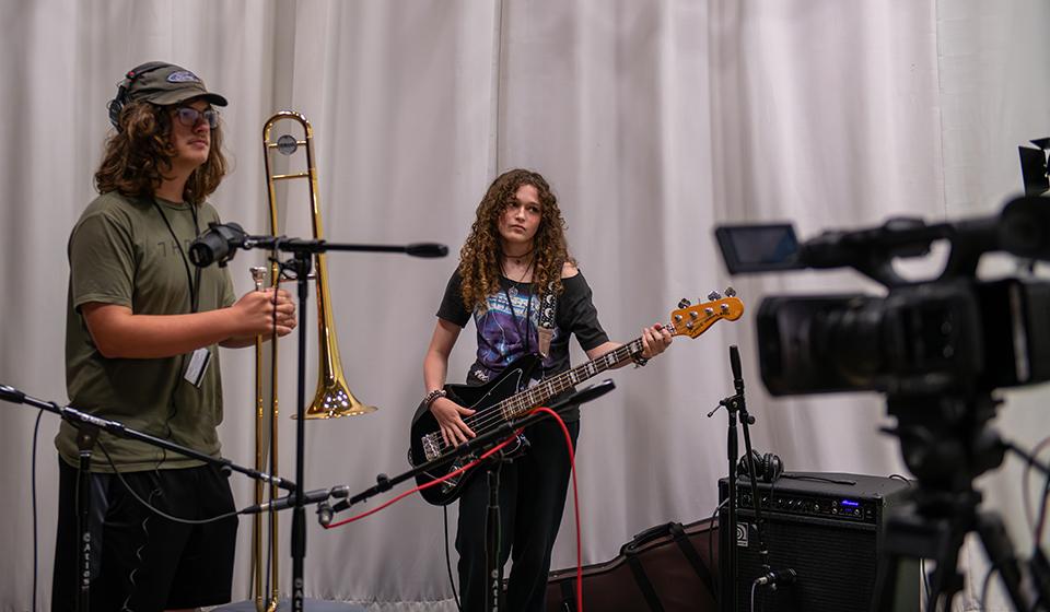two students playing a trombone and a guitar