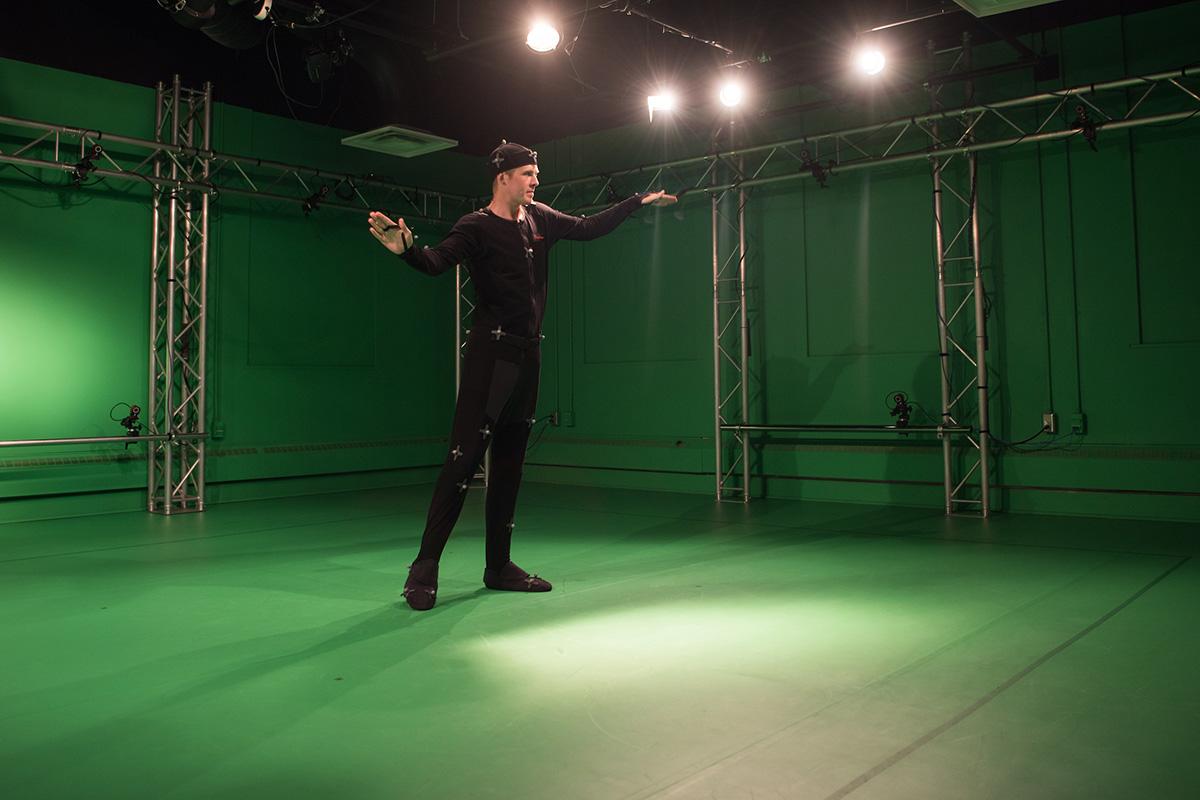 person in an all black suit posing in an motion capture lab