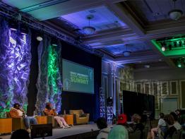 Two people speak on stage at the Music Industry Summit.