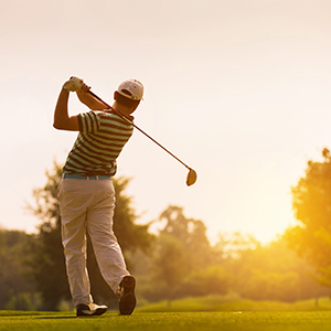 Golfer swings at a ball