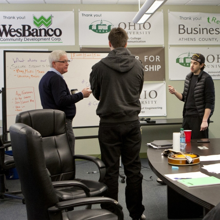 TechGROWTH Ohio staff talk in front of a whiteboard