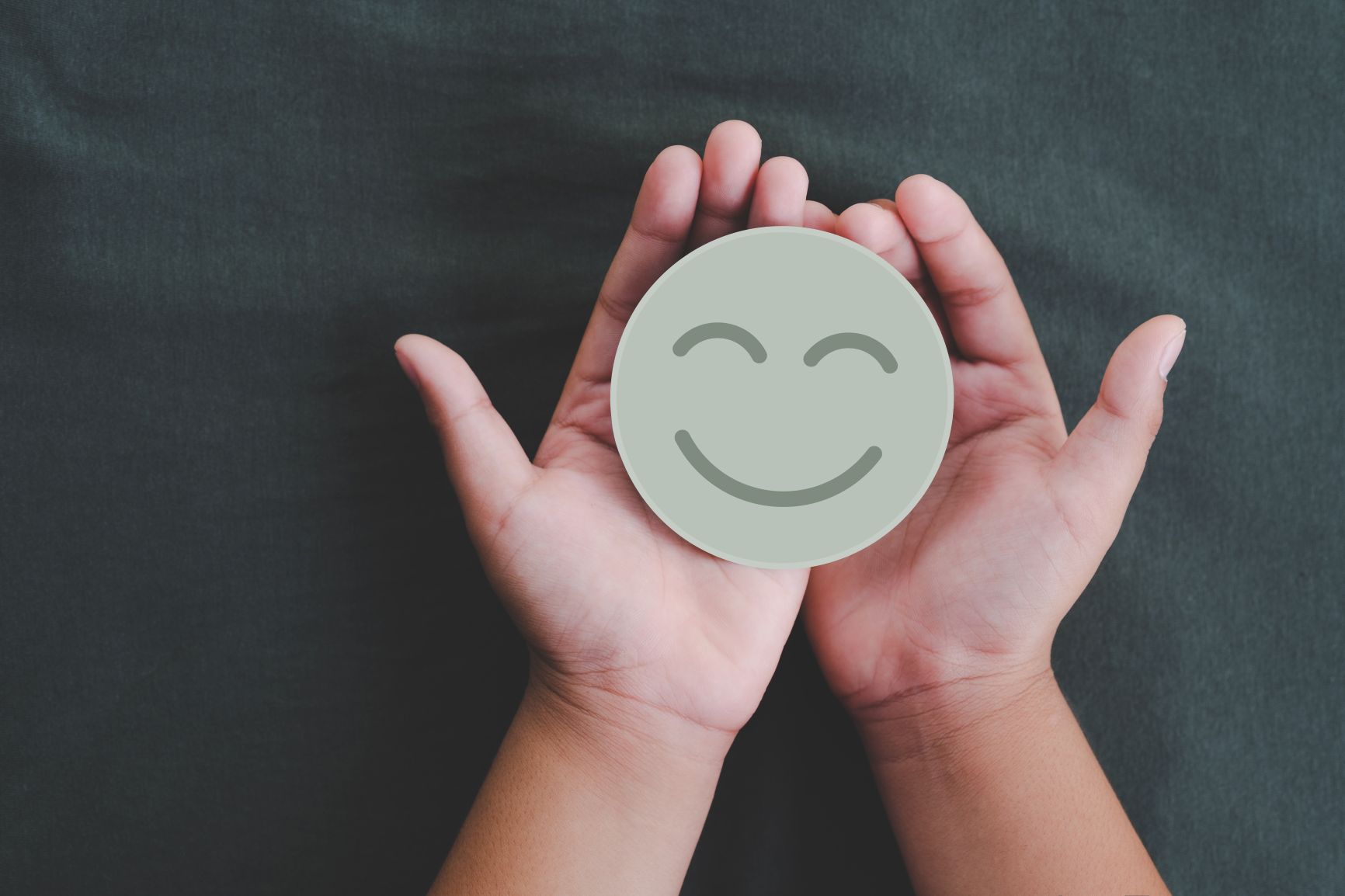 Two hands holding a circle with a smiley face