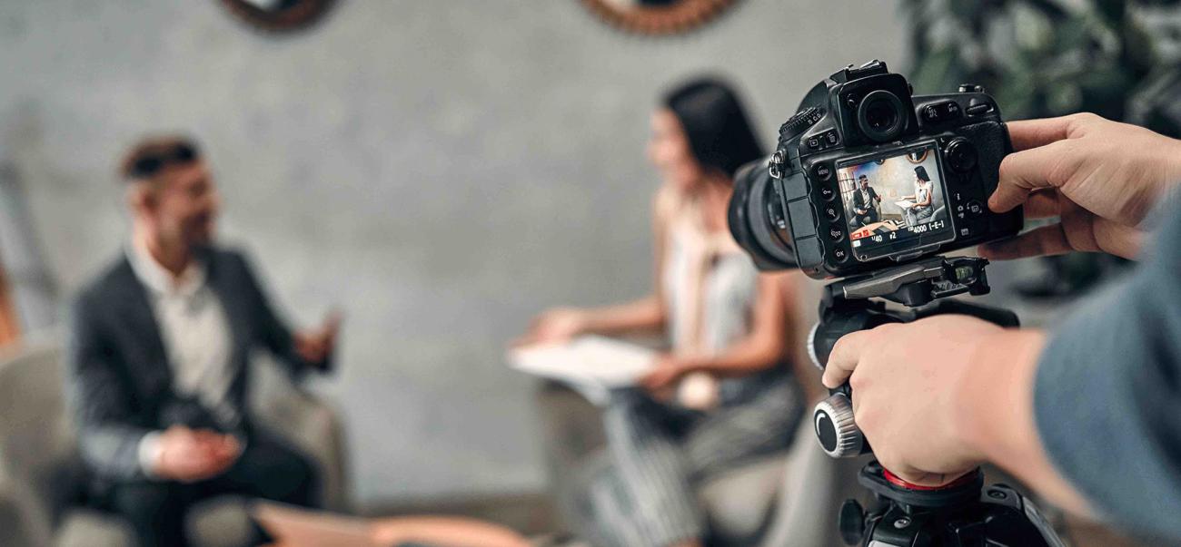 Camera filming an interview between two people