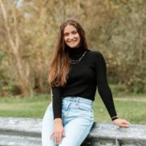Ashlyn Salesman wearing a black sweater and light wash jeans.