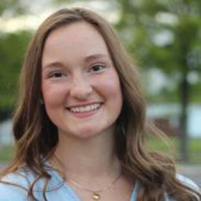 Baylee Wolfe smiles, wearing a light blue shirt.