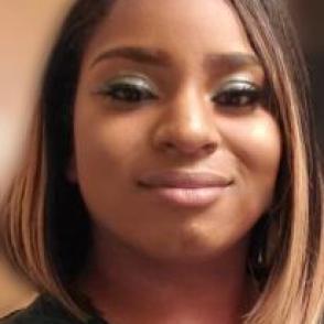 Courtney Ruffin smiling at the camera in a dark green shirt.