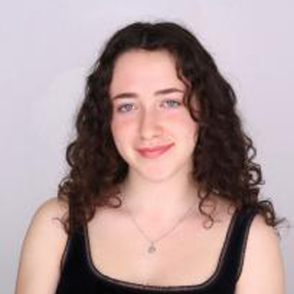 Isabella in a black tank top in front of a white wall.