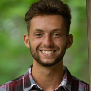Anthony Russo smiles at the camera, wearing a red and white flannel
