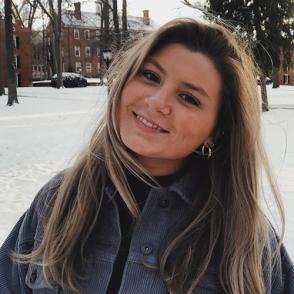 Brooke Klopfenstein smiles at the camera with snow in the background with a slightly tilted head.
