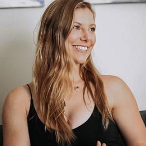 Carissa Nickell looks off-camera smiling and wearing a black tank top