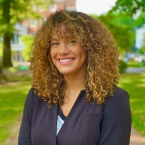 Micaylah Nash smiles and wears a dark gray blazer