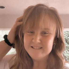 Molly Davis smiles and rests one hand against the side of Molly's head in a selfie photo.