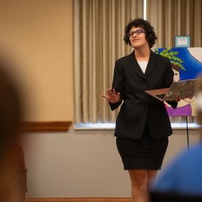 Woman in suit speaking to an audience