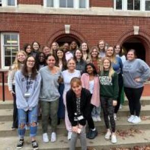 Students pose in front of a building