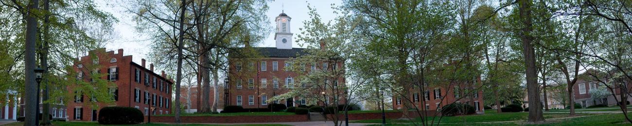Cutler Hall surrounded by trees and nearby buildings on College Green