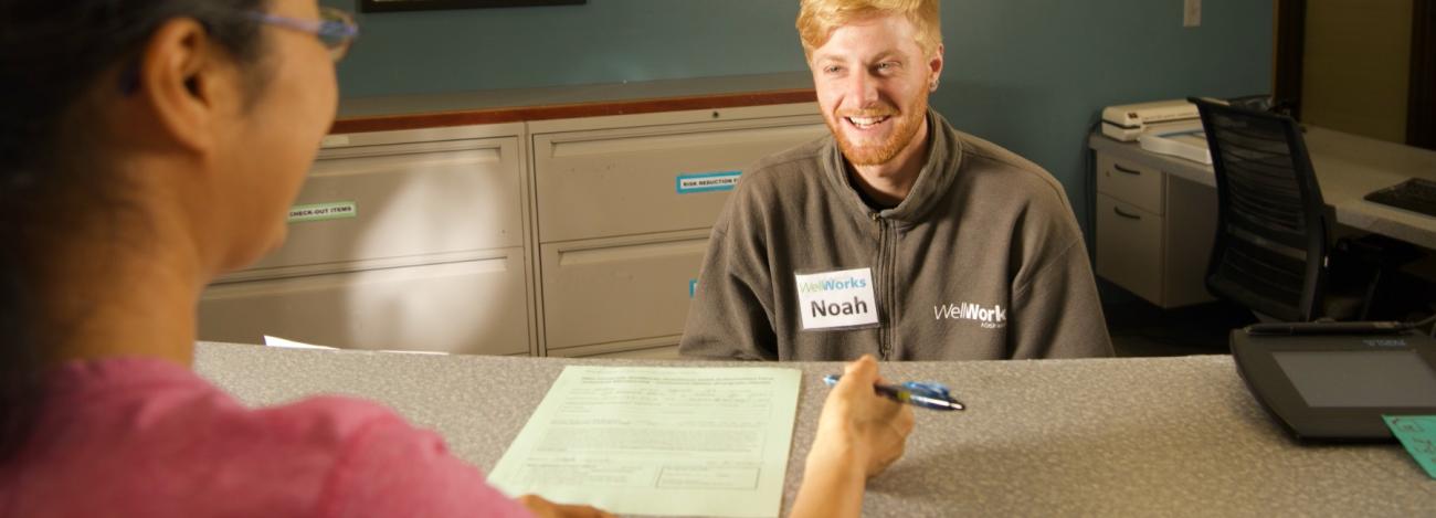 Client at front desk of wellness center with a Wellness Specialist