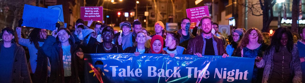 Marchers hold a banner that reads "Take Back the Night"