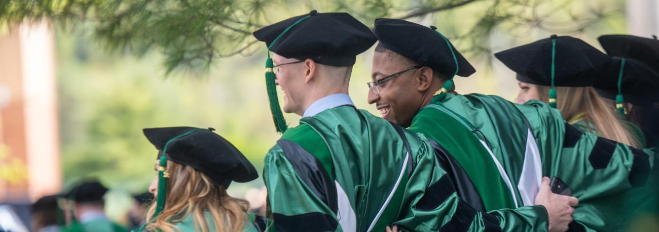 students pose at graduation