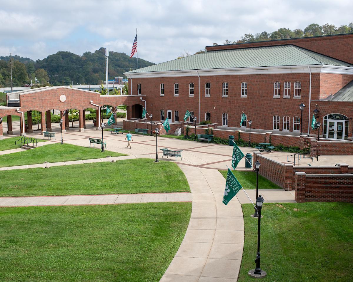 A courtyard with green grass surrounded by brick buildings
