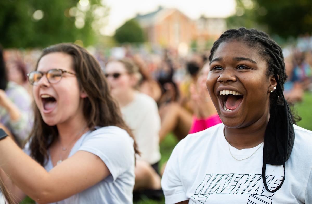 Two girls smile in an outdoor crowd