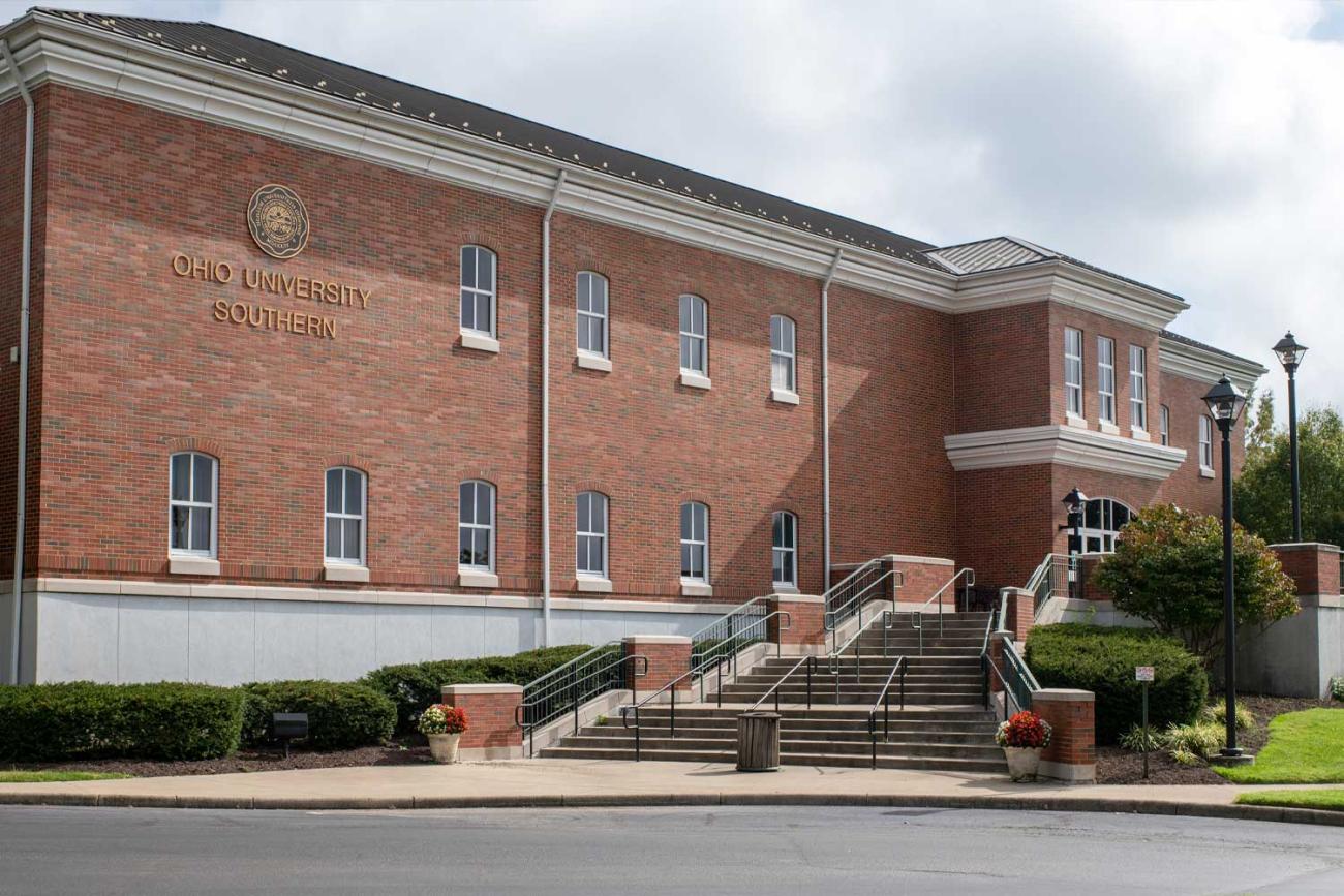 Southern campus library building exterior with a student walking up the stairs