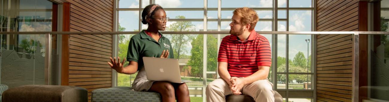 Orientation leader and student talking.