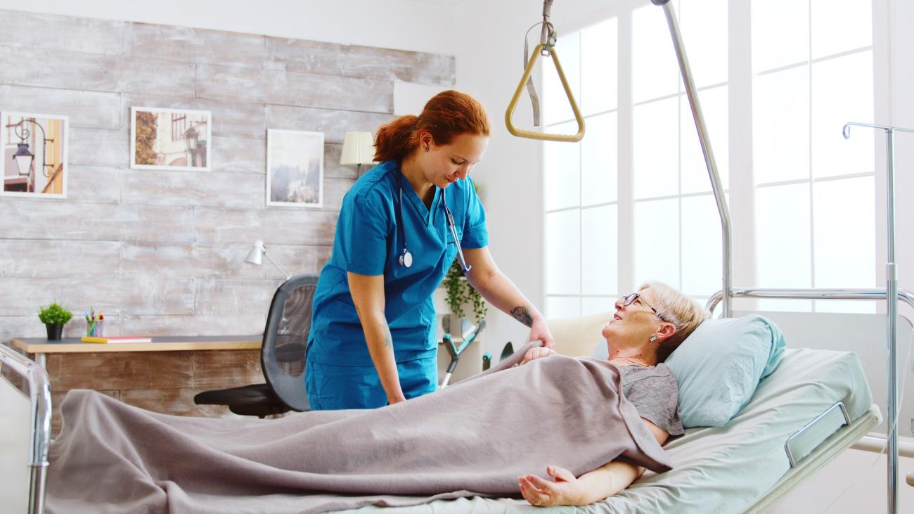  Female nurse helping an elderly woman to go to bed. Image by Freepik.