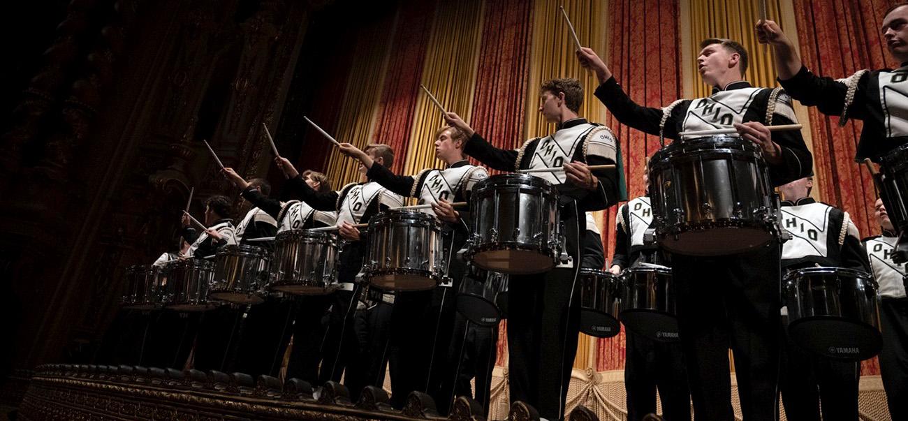 Marching band drummers in a row on a stage