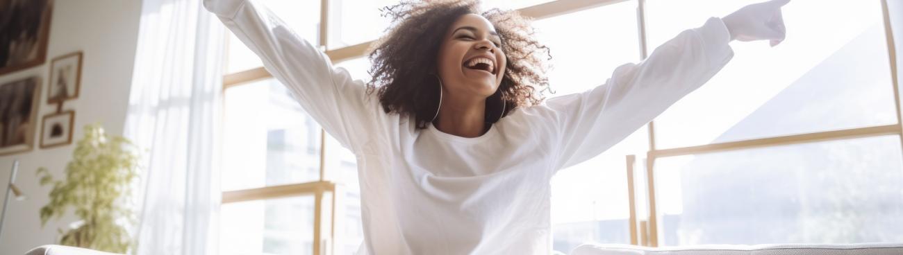 Happy woman wearing white with arms outstretched