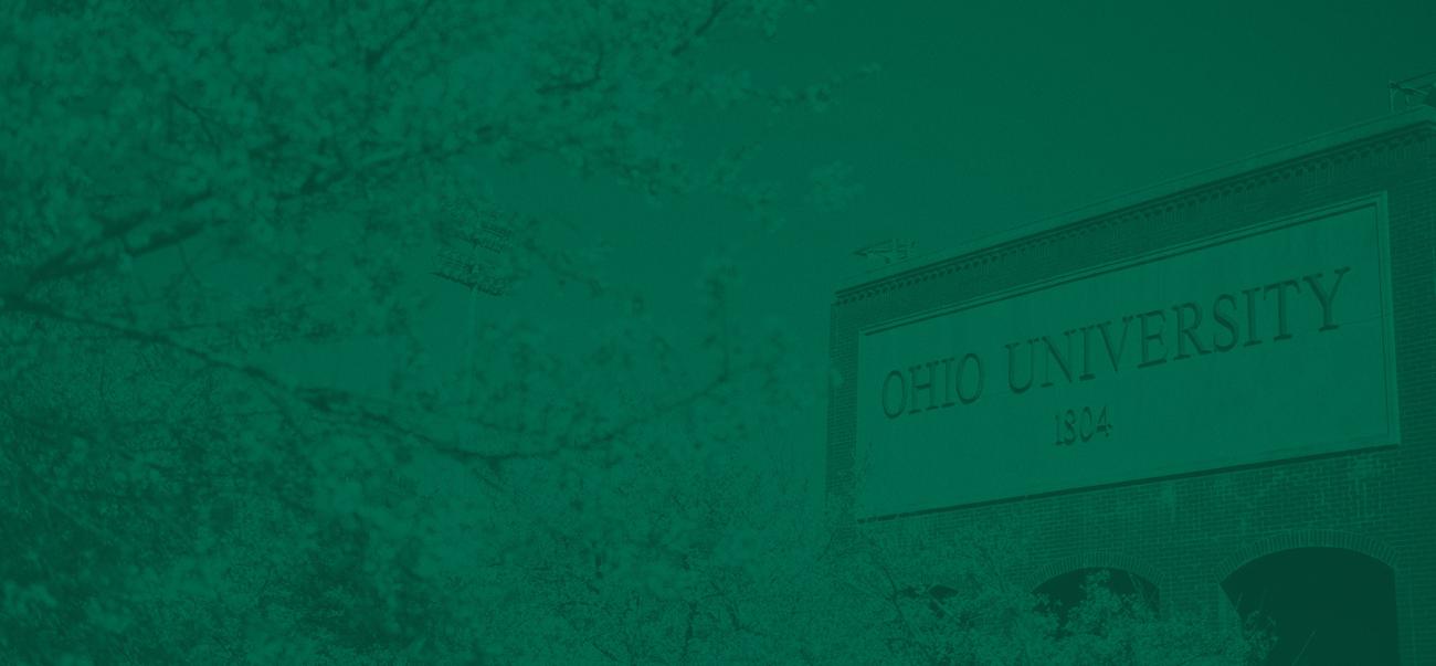 Flowering Cherry Blossoms with wall at Peden Stadium in the background reading "Ohio University"