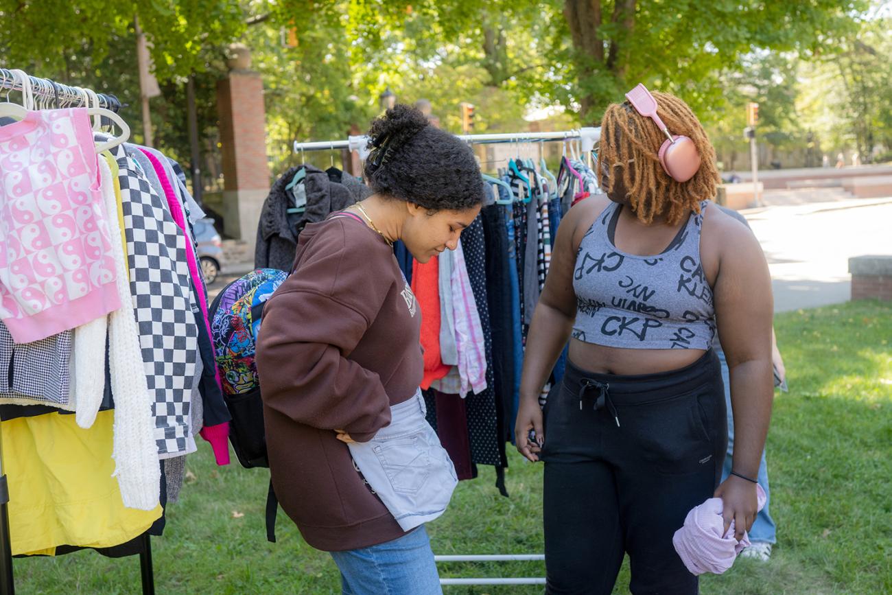 Two students on College Green at a pop-up shop with clothes racks