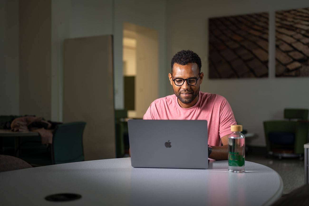 man sitting at a table with a laptop