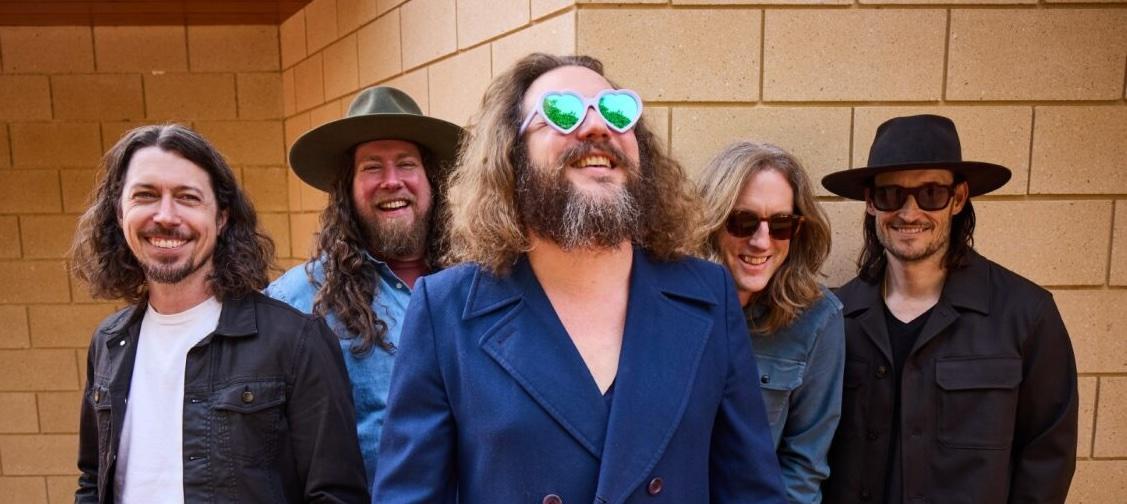 Five members of My Morning Jacket in front of a brick wall
