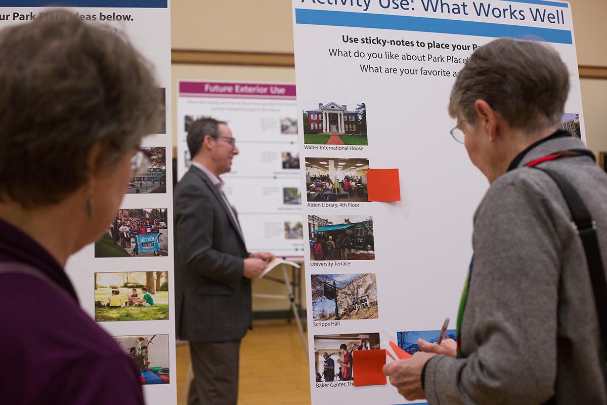 People look at a board with information about University buildings during a planning session.