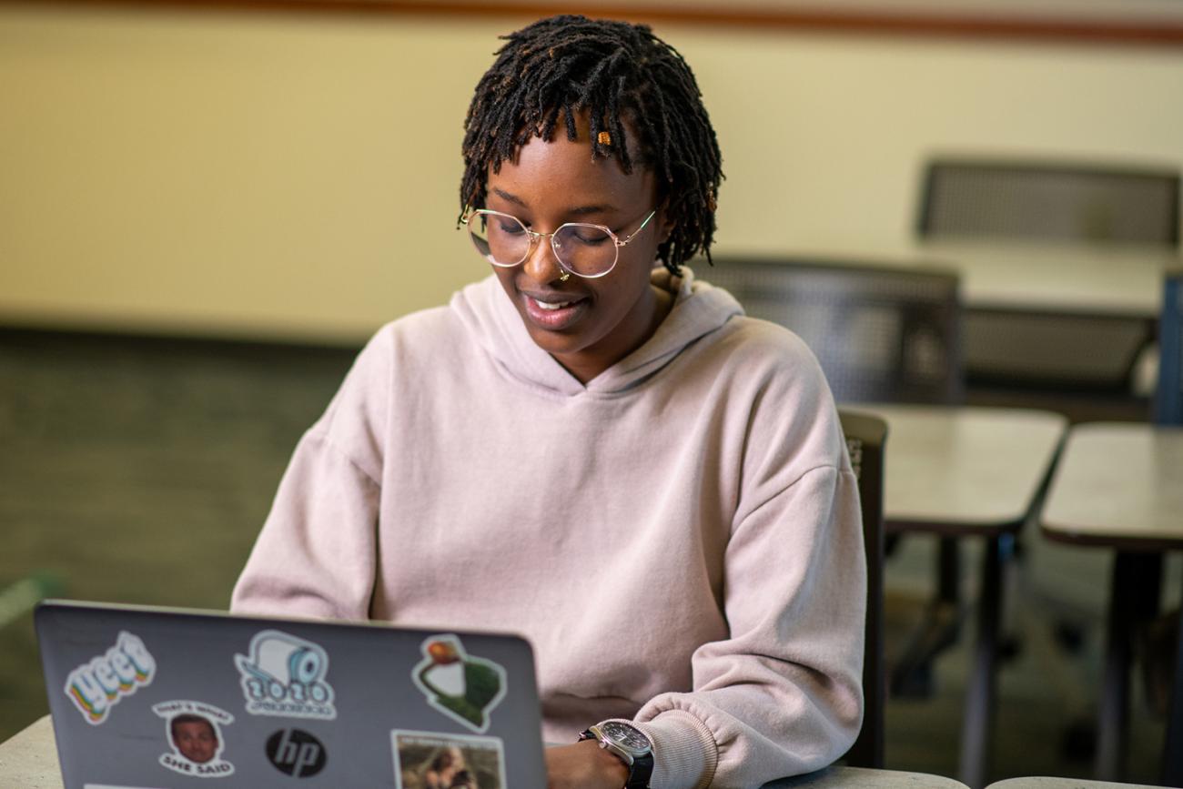 woman siting at laptop on a desk typing
