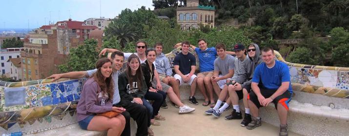 Group of students sitting on a stone bench in Spain