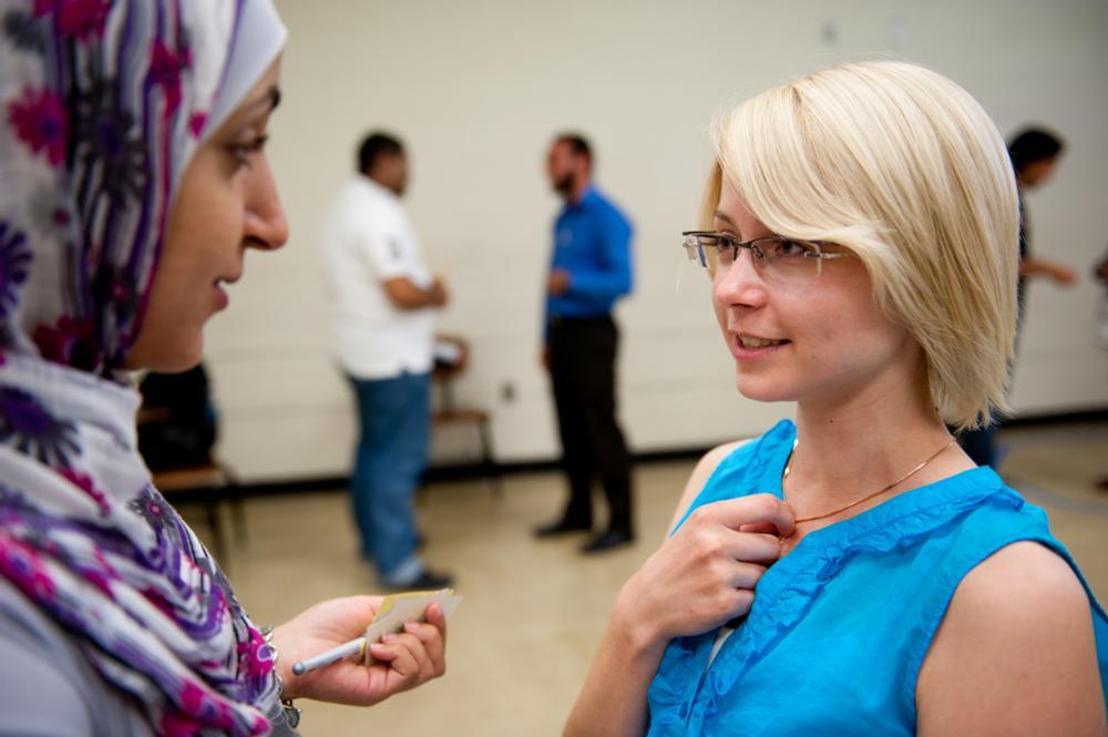 Two participants speaking together in a large auditorium. 