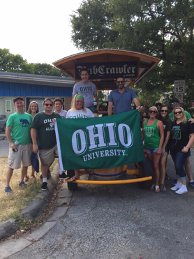 A group of Alumnus holding up a flag