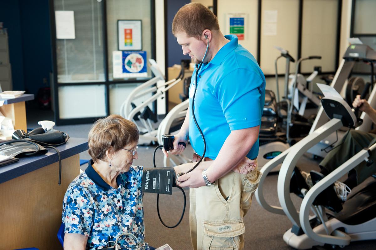 HeartWorks staff taking blood pressure reading of a patient.