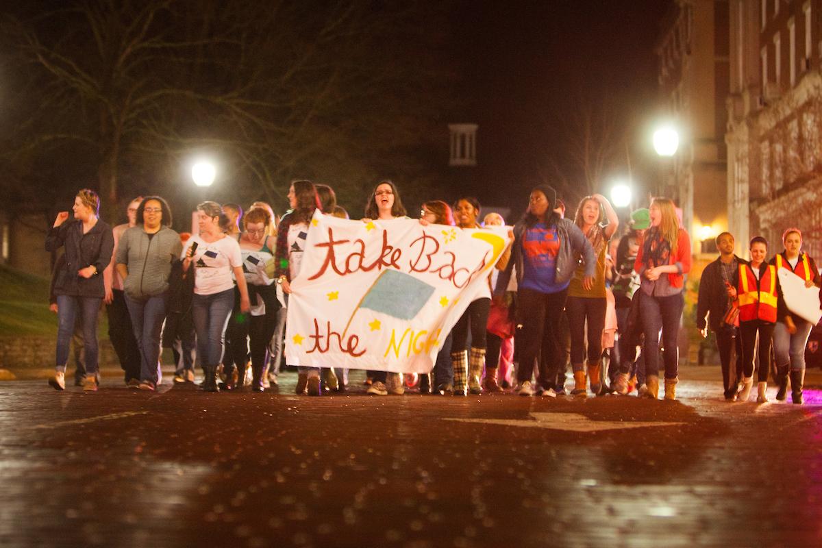 Marchers hold a banner a chant