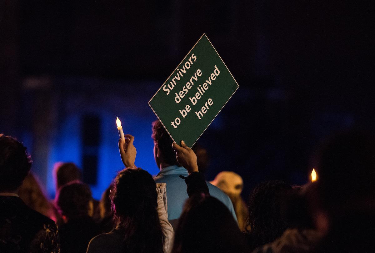 A marcher holds up a sign that says "survivors deserve to be believed here"