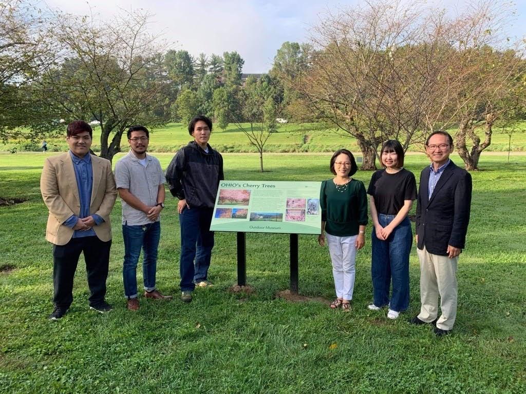 Chubu University students and Global Affairs leadership standing next to museum complex sinage