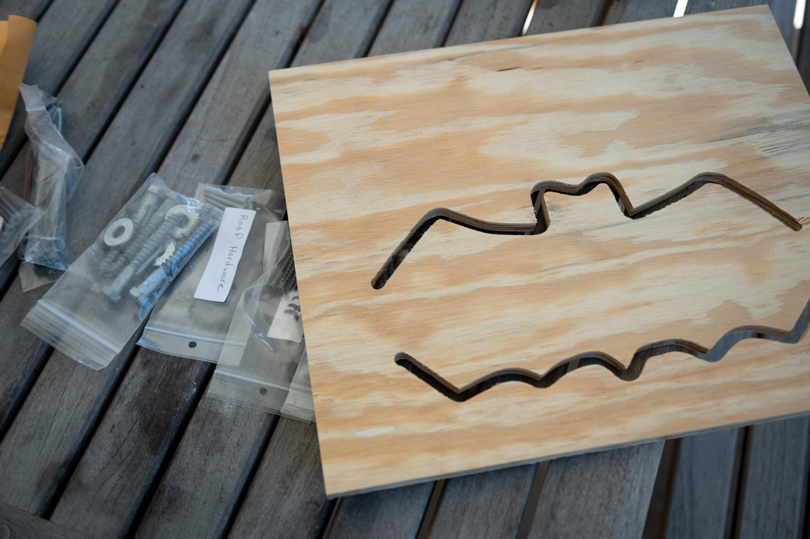 An unpainted bat house sits on a table.
