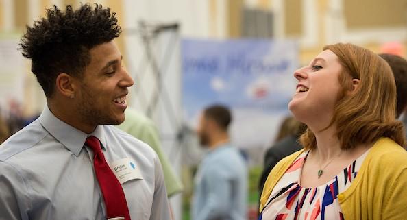 Two people talking at a career fair