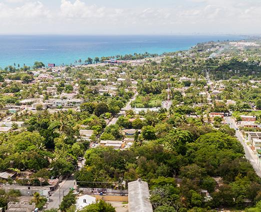 Overview of tree filled city with the coastline in the upper left corner.