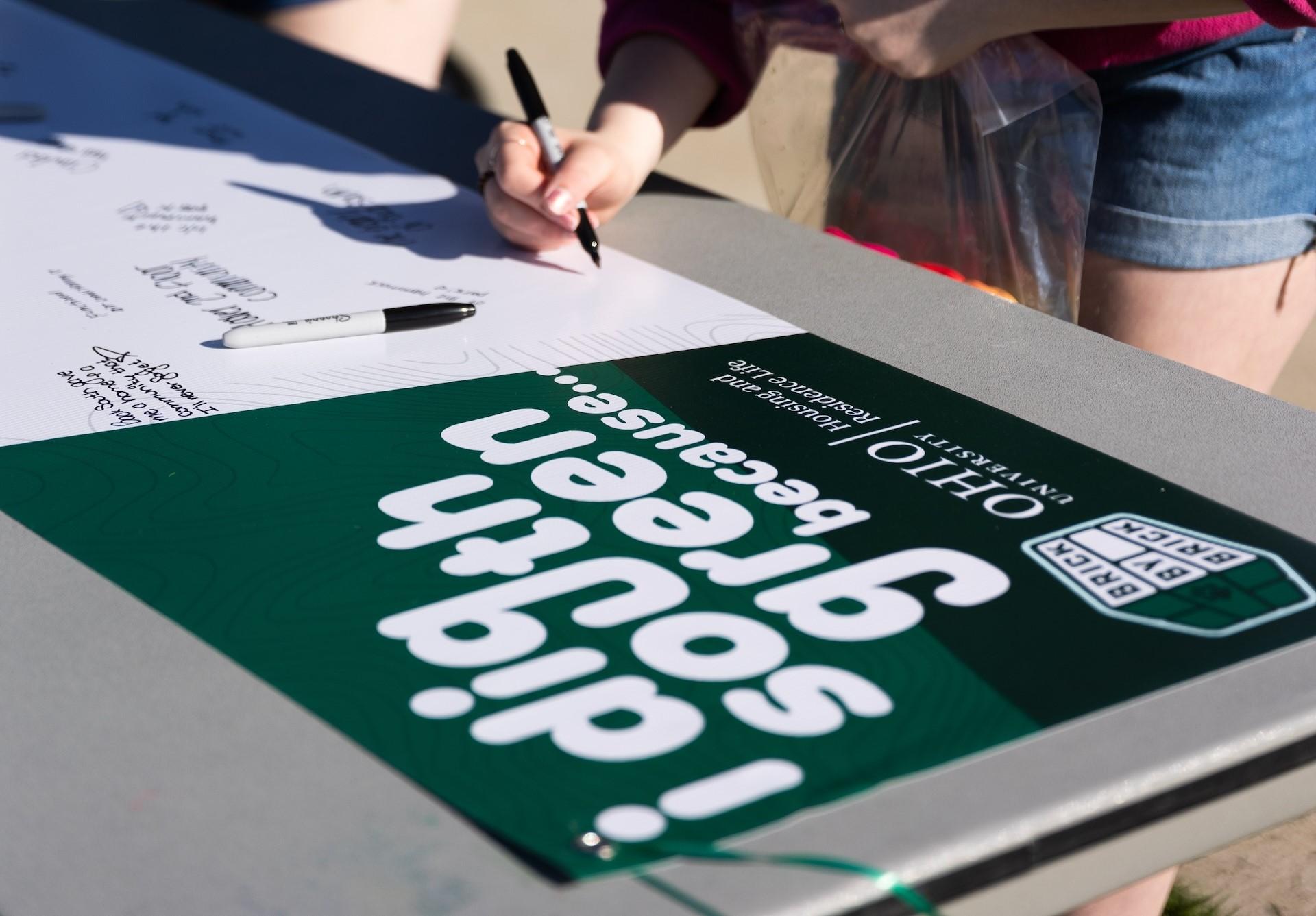 vinyl banner being written on by students