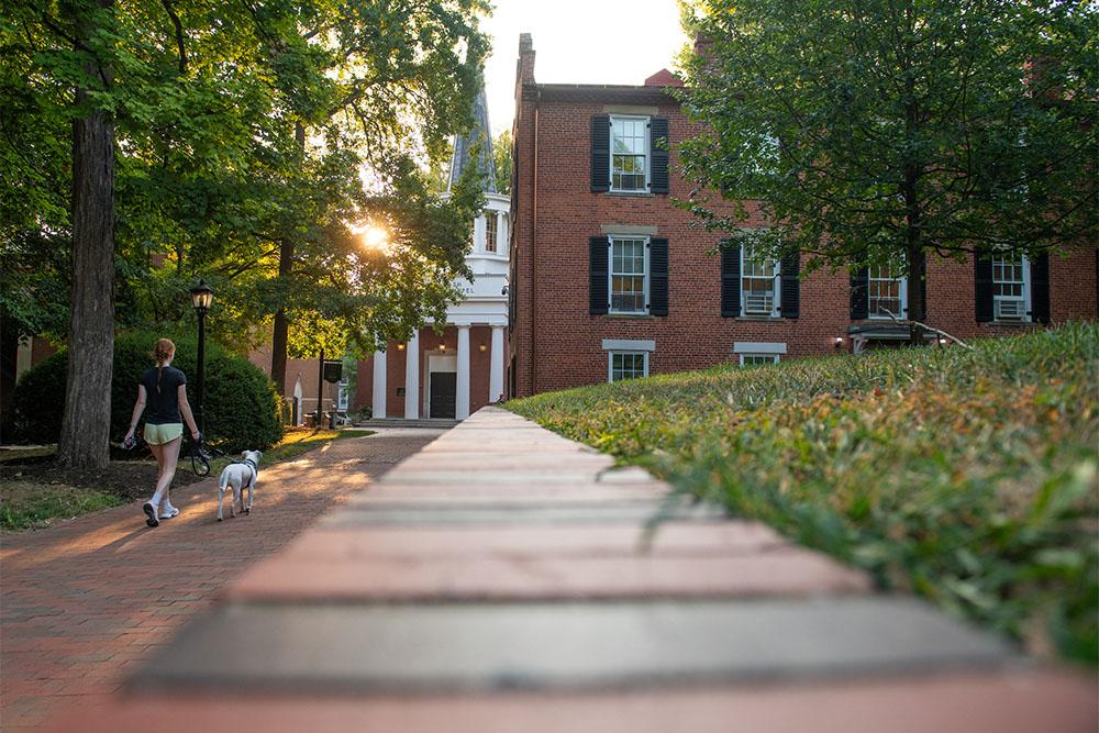 A student walks their dog through campus on the first day of class.