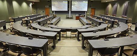 Classroom inside of Walter Hall, featuring u-shape seating with tables and chairs