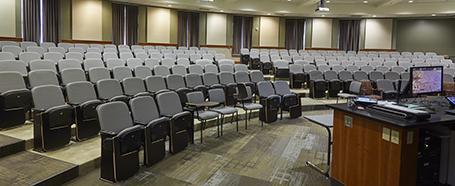 Classroom inside of Walter Hall, featuring seating with a podium at the front for presentations